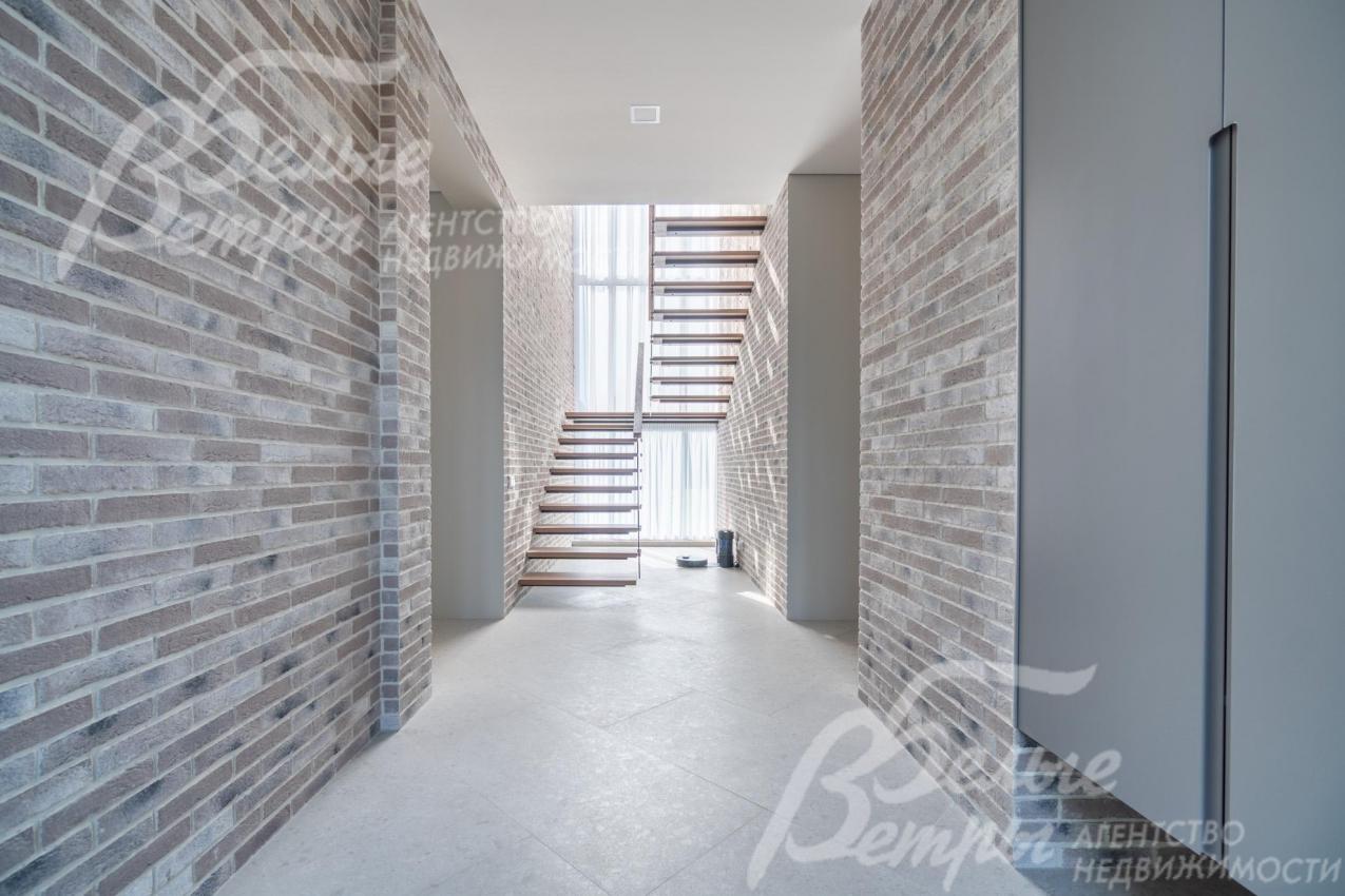 Холл дома: стены отделаны декоративной плиткой «под фасадный кирпич», они органично продолжают внешнюю отделку дома