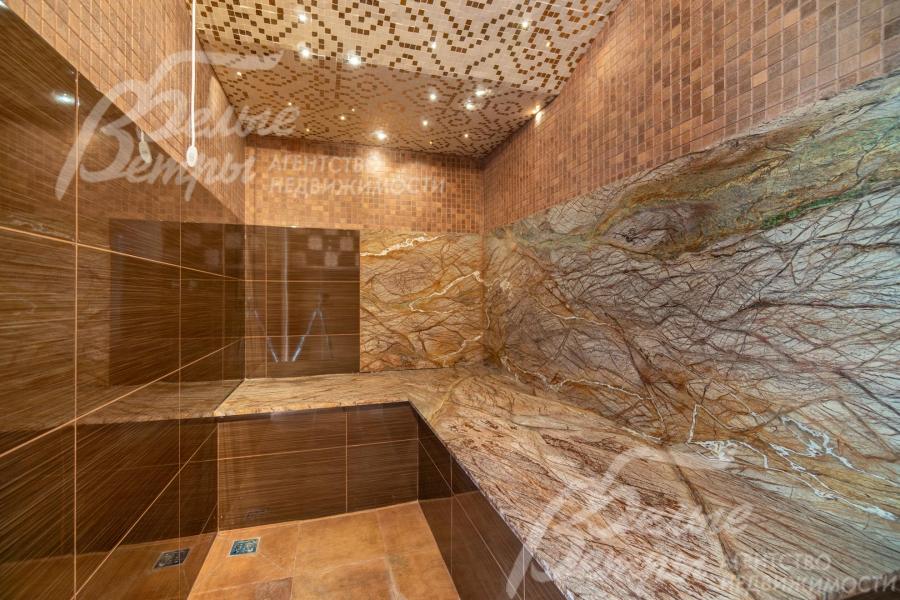 На первом этаже дома есть хамам с коричневыми оттенками в отделке