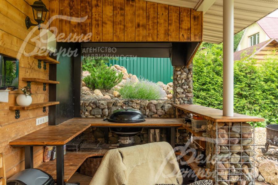 Беседка декорирована габионами, установлен гриль