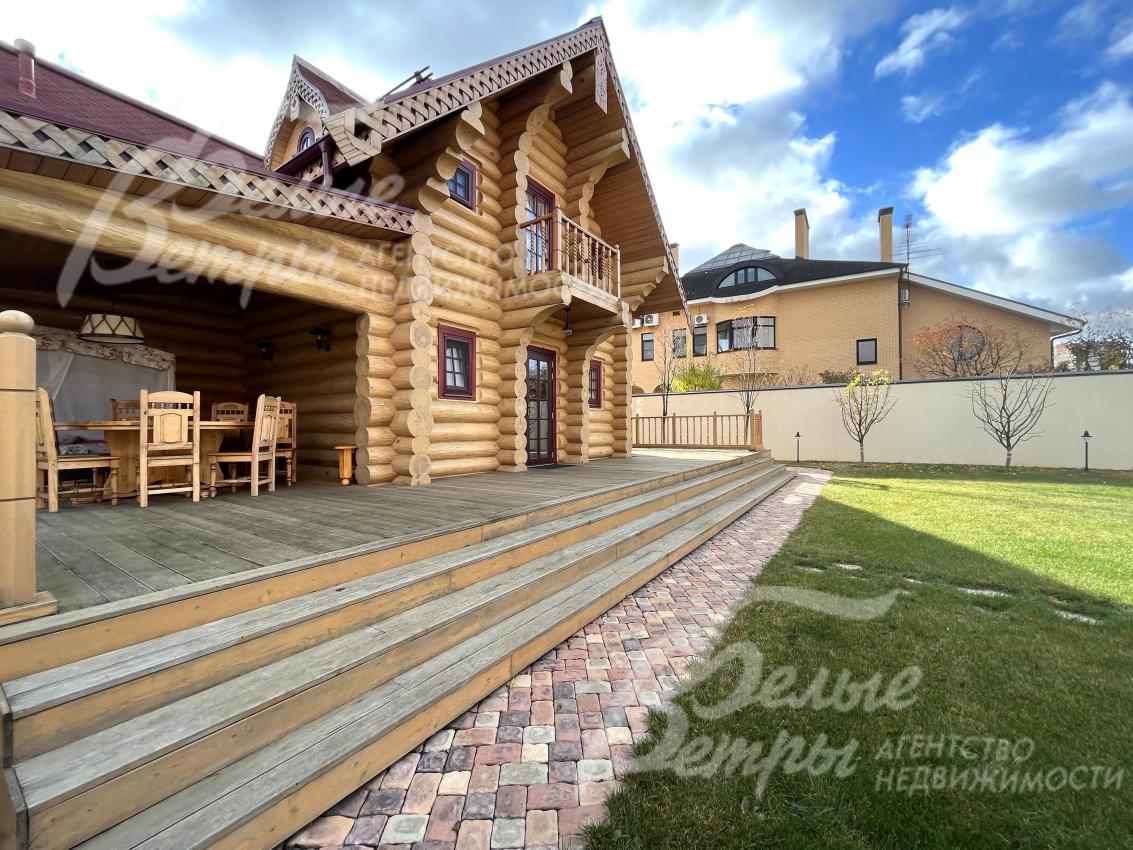 С одной из сторон дома - терраса с мебелью и выходом на участок