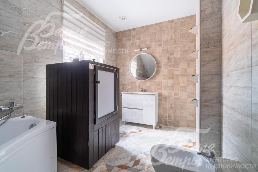 Санузел оформлен плиткой в светлых тонах, в нём есть окно и ванна