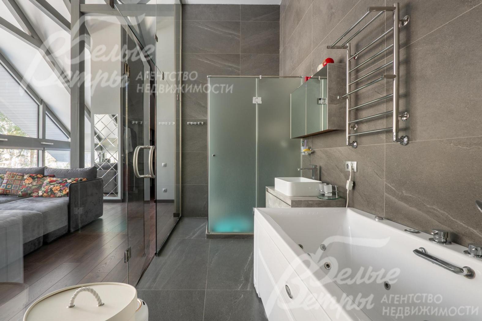 Санузел мастер-блока - с гидромассажной ванной и душевой, его интерьер выполнен в современном минималистичном стиле с акцентом на функциональность и эстетику