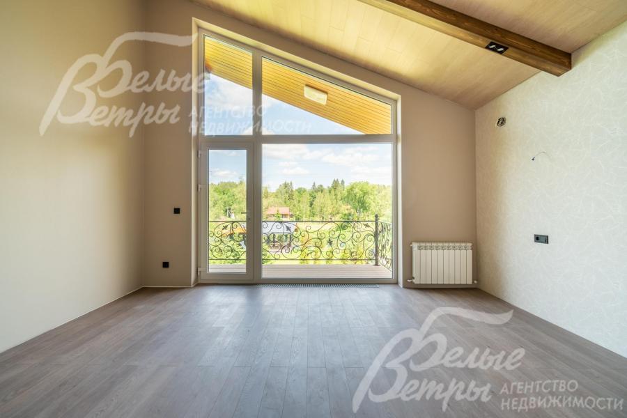 Спальня на втором этаже с большим окном в пол и выходом на балкон