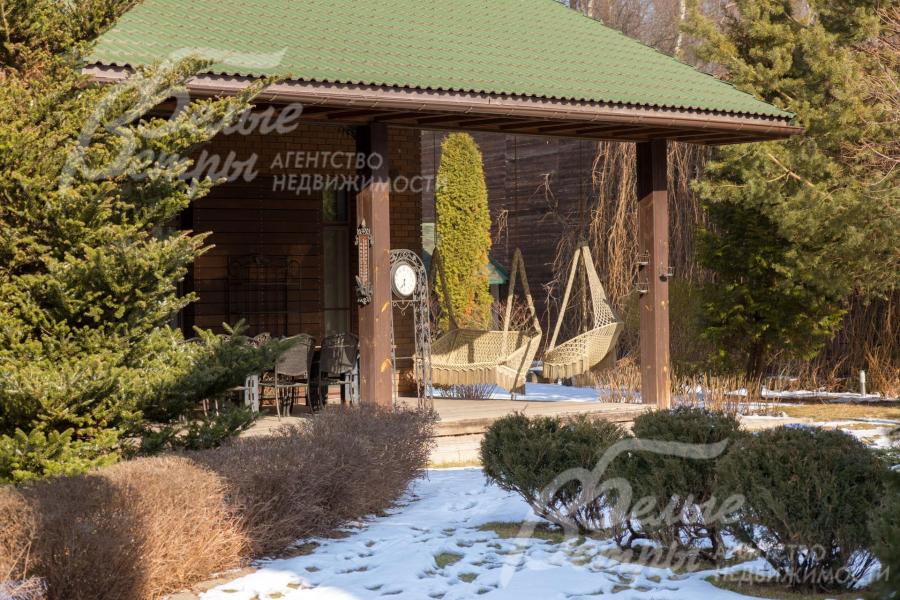 На участке – эффектный парковый ландшафт по индивидуальному дизайн-проекту, дорожки выложены из камня и плитки, выполнено освещение, засеян газон, высажены разнообразные деревья, цветы и кустарники