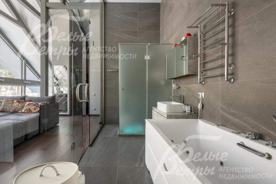 Санузел мастер-блока - с гидромассажной ванной и душевой, его интерьер выполнен в современном минималистичном стиле с акцентом на функциональность и эстетику