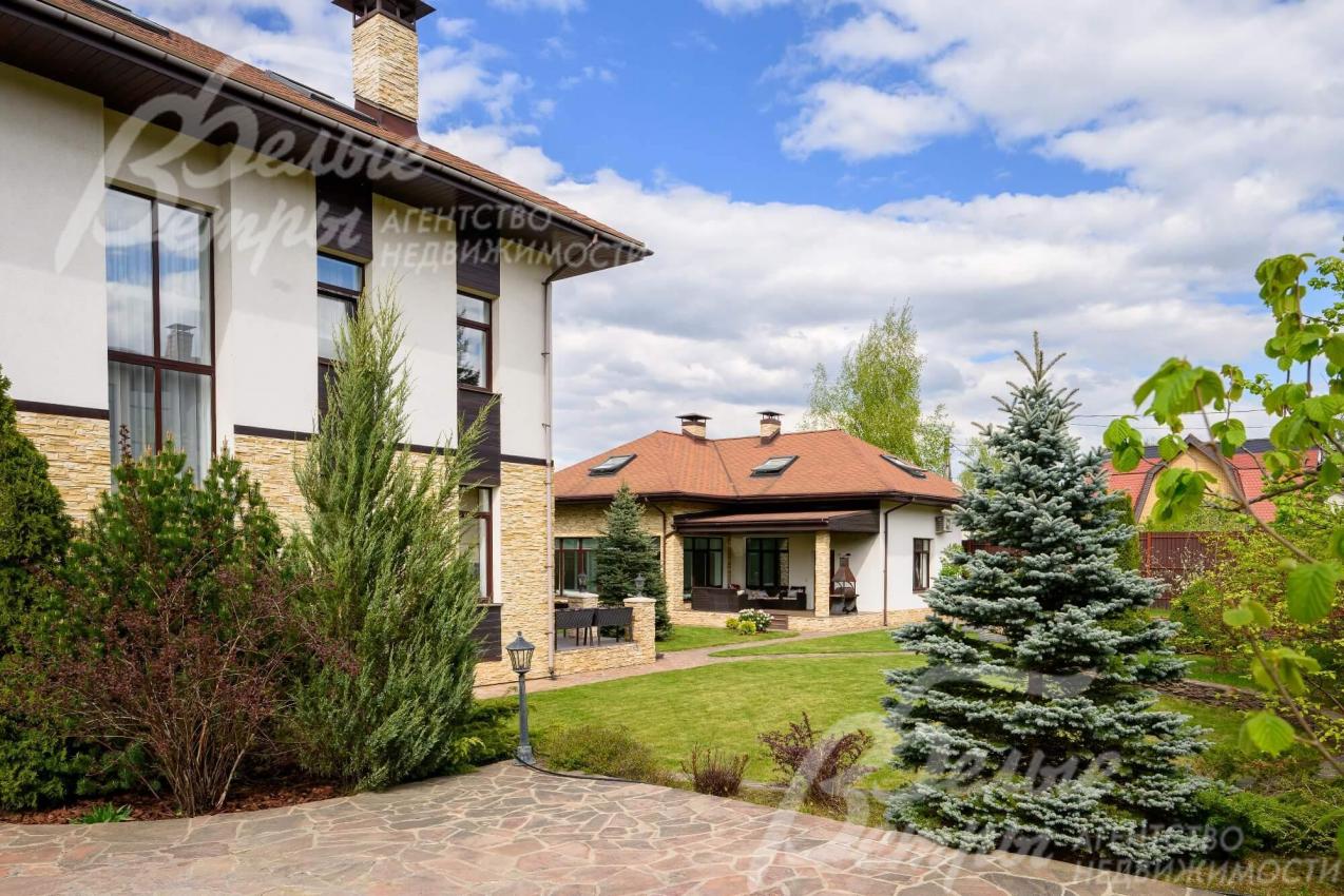 Дорожки и отмостки выложены натуральным камнем, высажены туи, плодовые деревья и кустарники.