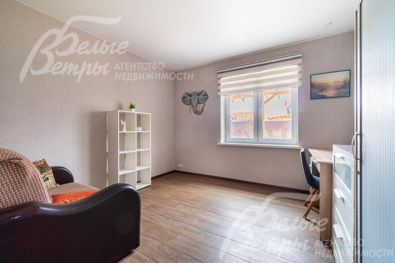 Спальня на первом этаже также может использоваться как кабинет: в комнате есть диван, системы хранения и рабочее места