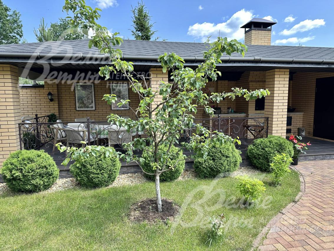 Кирпичные столбы соединяют кованные черные перила в винтажном стиле.