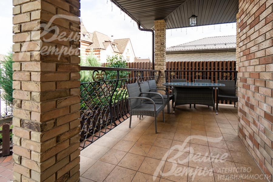 Просторная крытая терраса с мебелью