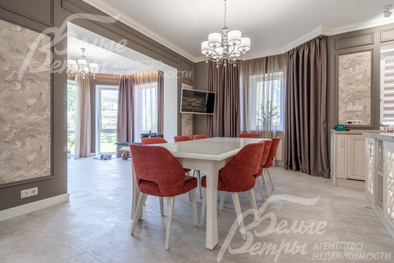 Единое пространство столовой и кухни в изящном классическом стиле в светло-бежевых тонах с яркими акцентами