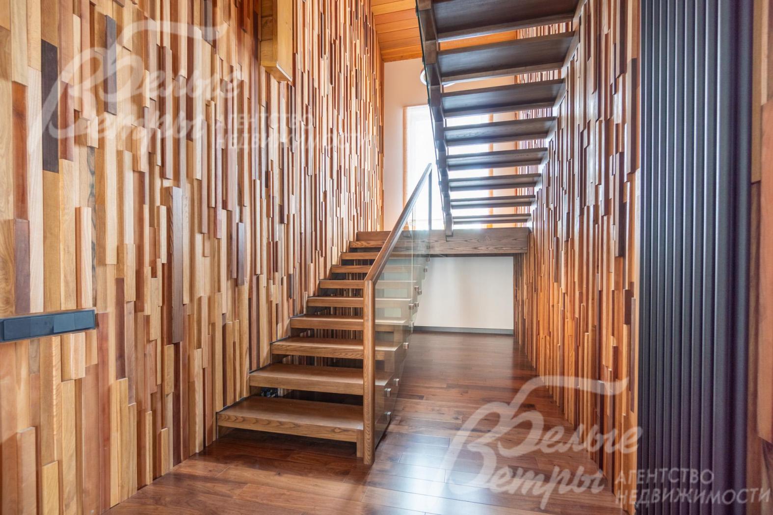 На второй этаж ведет лестница из массива дуба со стеклянным ограждением
