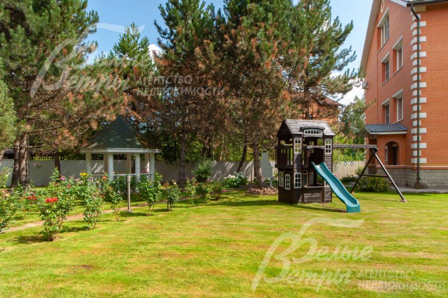 Детская игровая горка с качелями на участке.