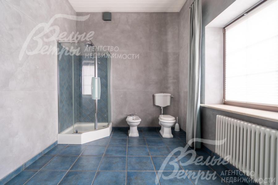 В санузле - угловая душевая кабина, унитаз и биде, большое окно