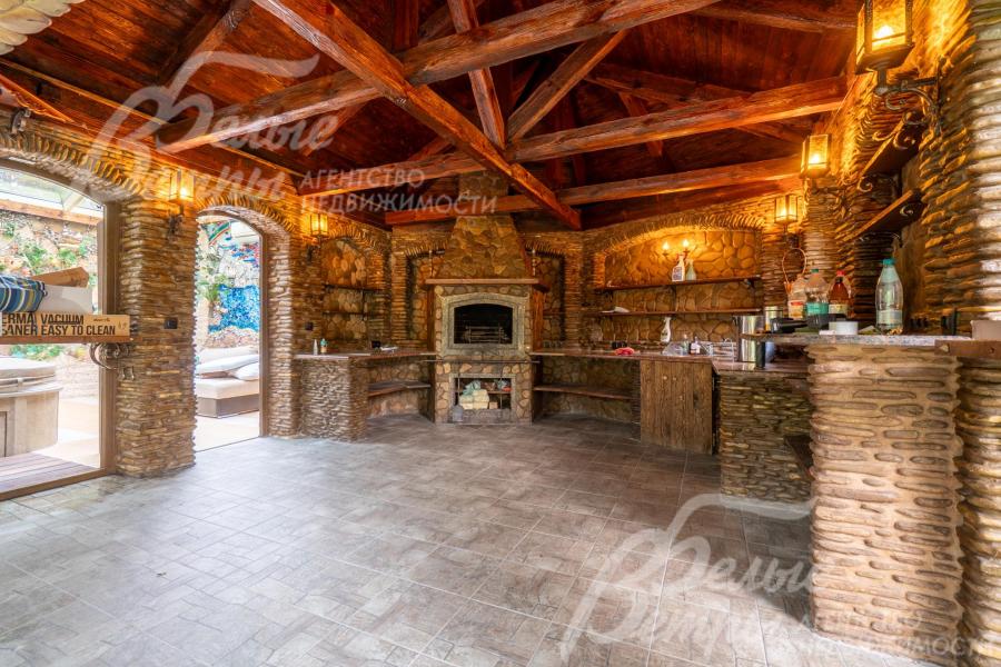 Беседка оборудована печью, стены отделаны "под камень"