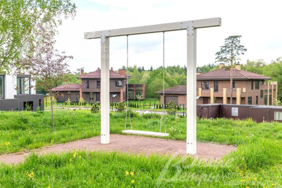 Качели в общественной прогулочной зоне поселка 