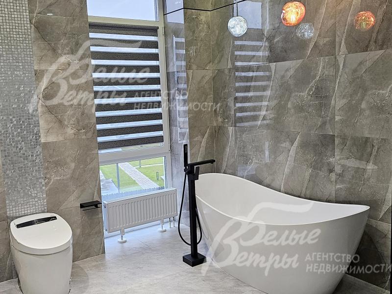 В санузле при мастер-спальне - ванна из литьевого мрамора возле окна