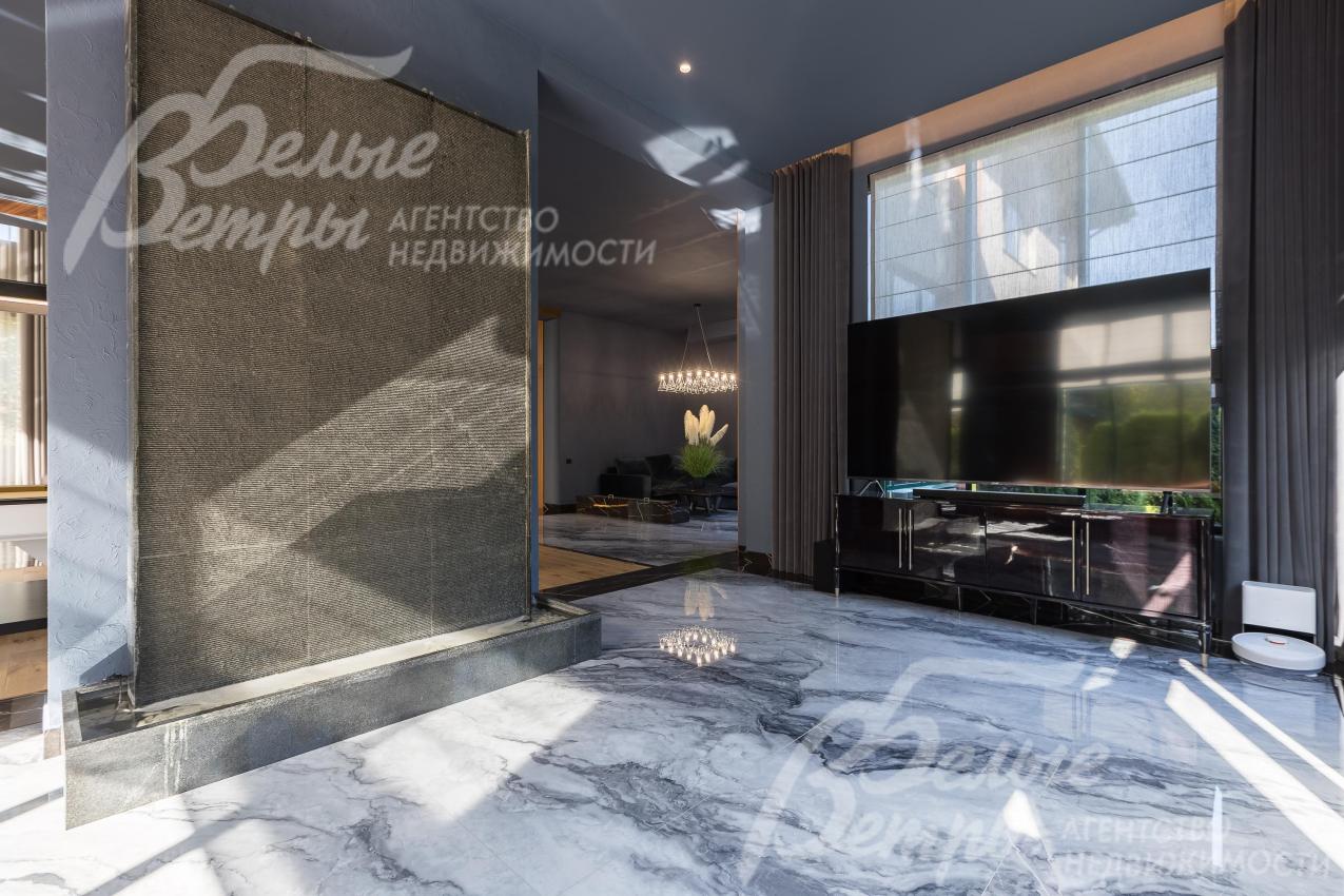 Напротив дивана установлен телевизор с диагональю 98 дюймов