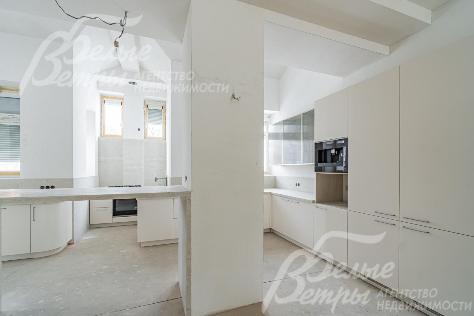 Кухня-столовая с дизайнерским кухонным гарнитуром,  островом и баром. 