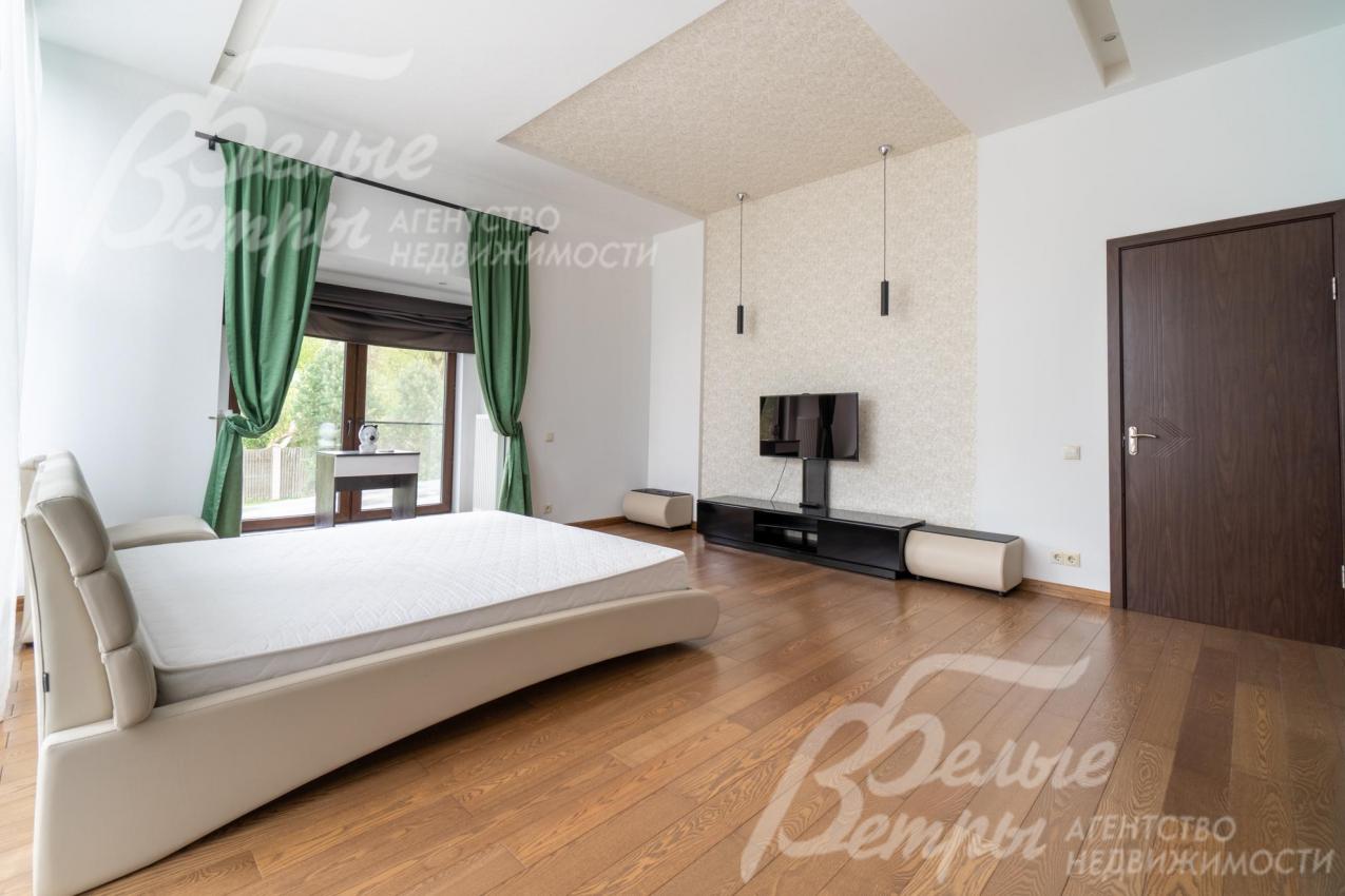 Мастер-спальня с большим окном, в светлых тонах в стиле минимализма.