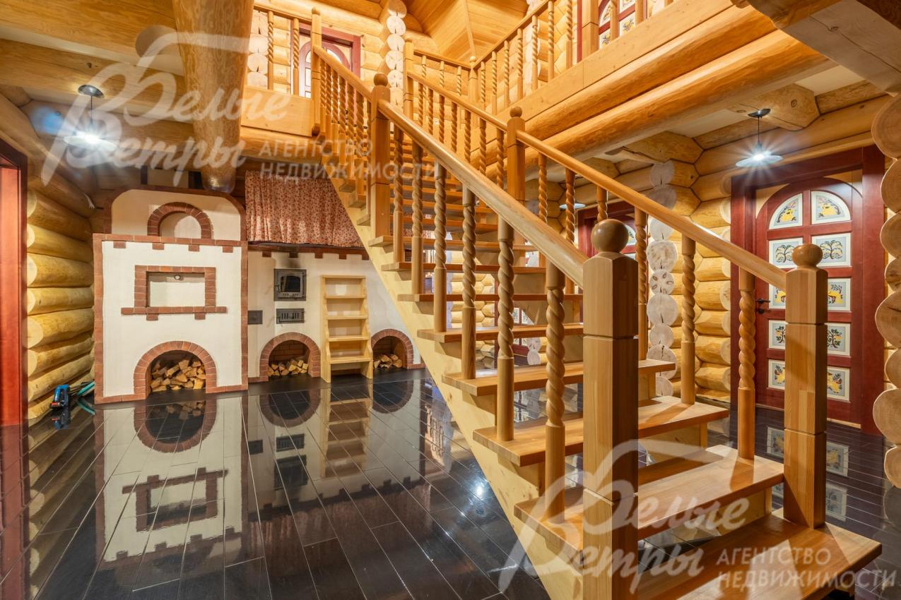 На второй этаж ведёт статная лестница из массива дерева с декоративными резными балясинами