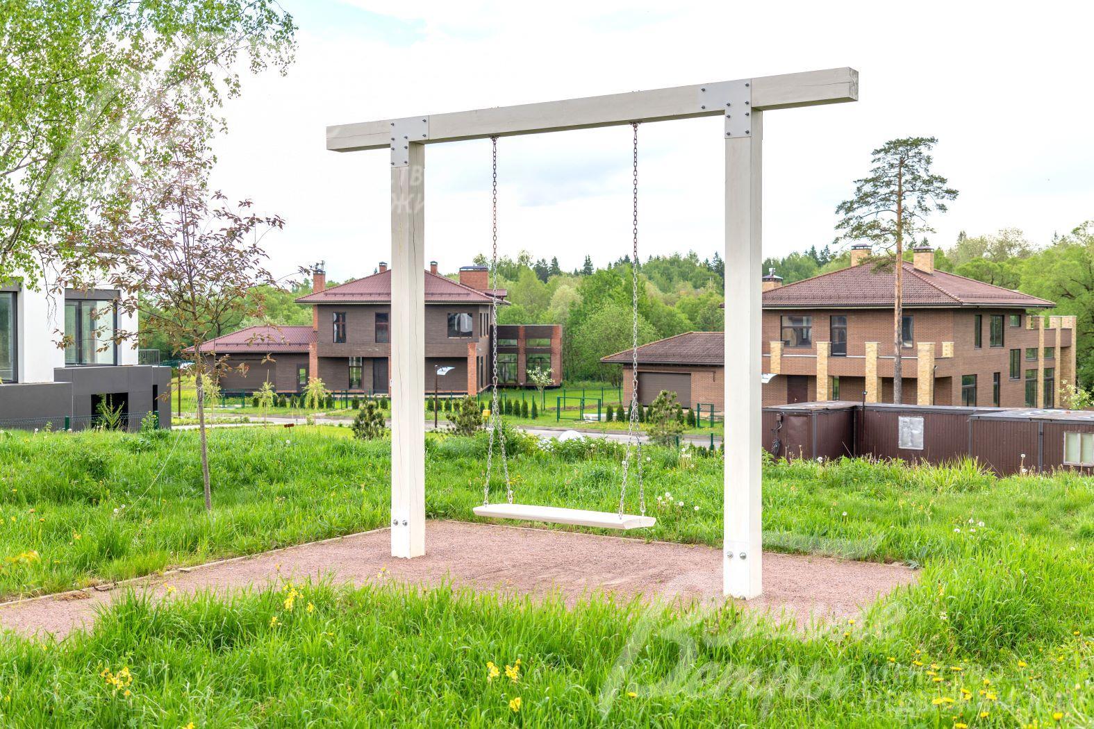 Качели в общественной прогулочной зоне поселка 