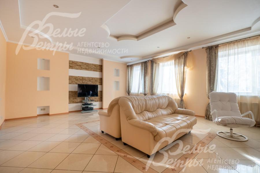 В гостиной обустроены зона отдыха у камина и отдельная зона с телевизором