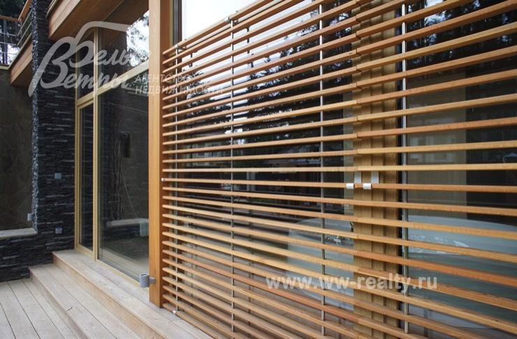 Декоративные деревянные жалюзи на окнах снаружи дома