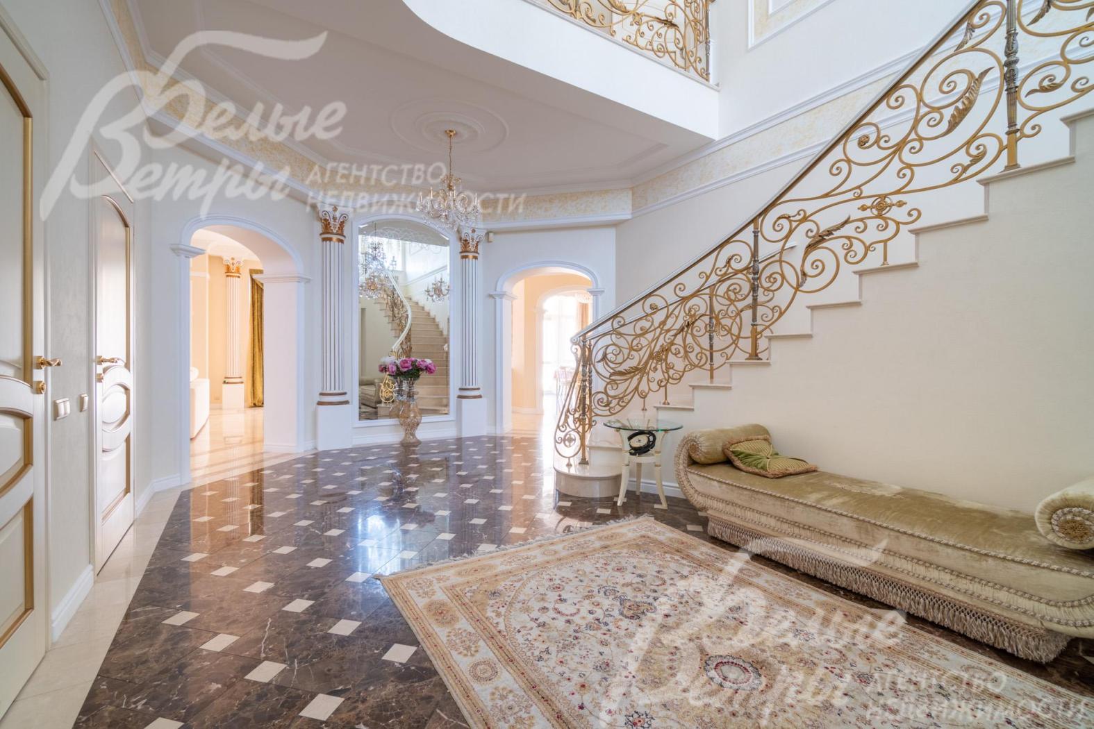 Холл первого этажа - со вторым светом, оформлен штукатуркой в светлых тонах и мраморной плиткой Имперадор Дарк с бежевыми квадратными вставками из мрамора Крема Марфил