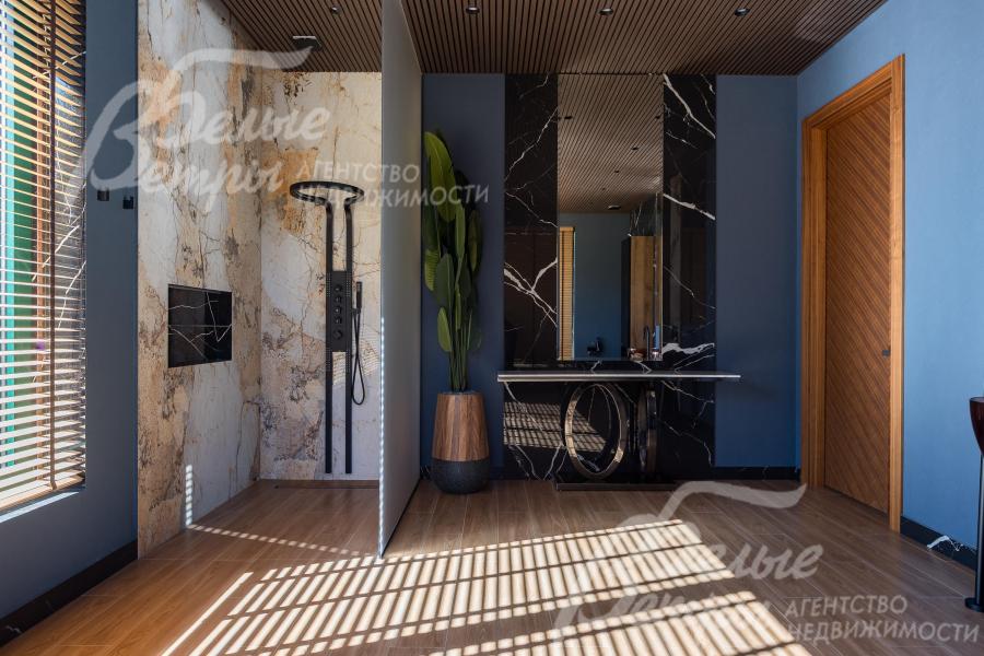 В санузле мастер-спальни также есть просторная душевая кабина, отделанная слэбами мрамора