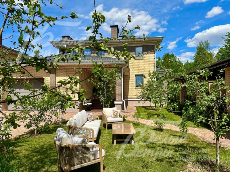 На участке газон, высажены молодые деревья.