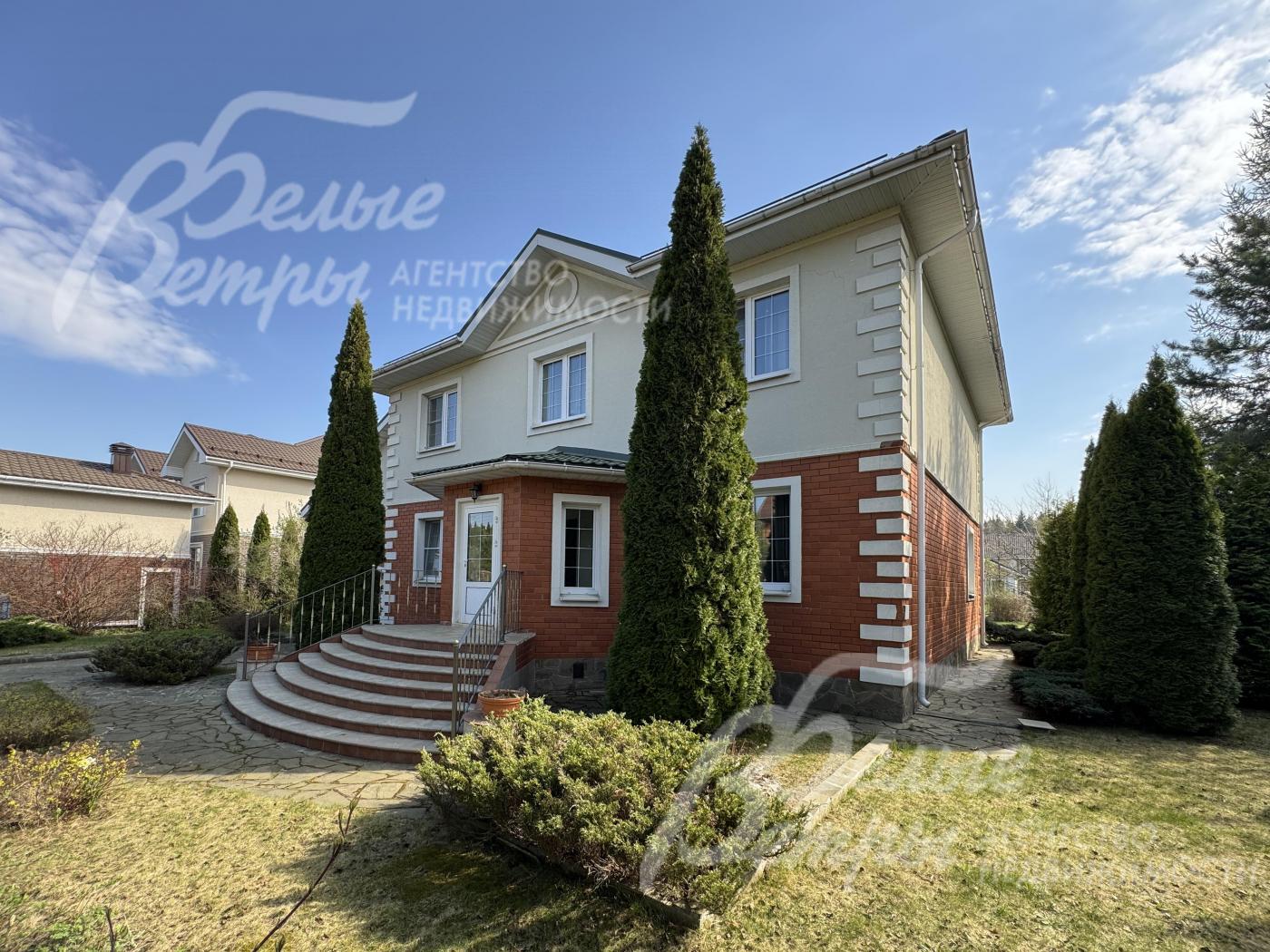 У парадного крыльца высажены две высокие взрослые туи