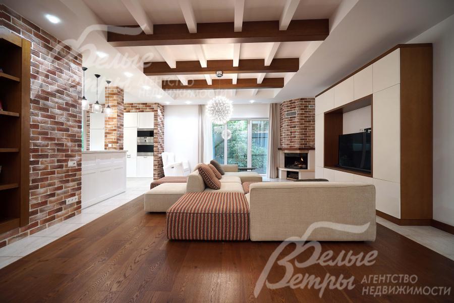 Гостиная с акцентными стенами с отделкой "под кирпич" и декоративными деревянными балками на потолке