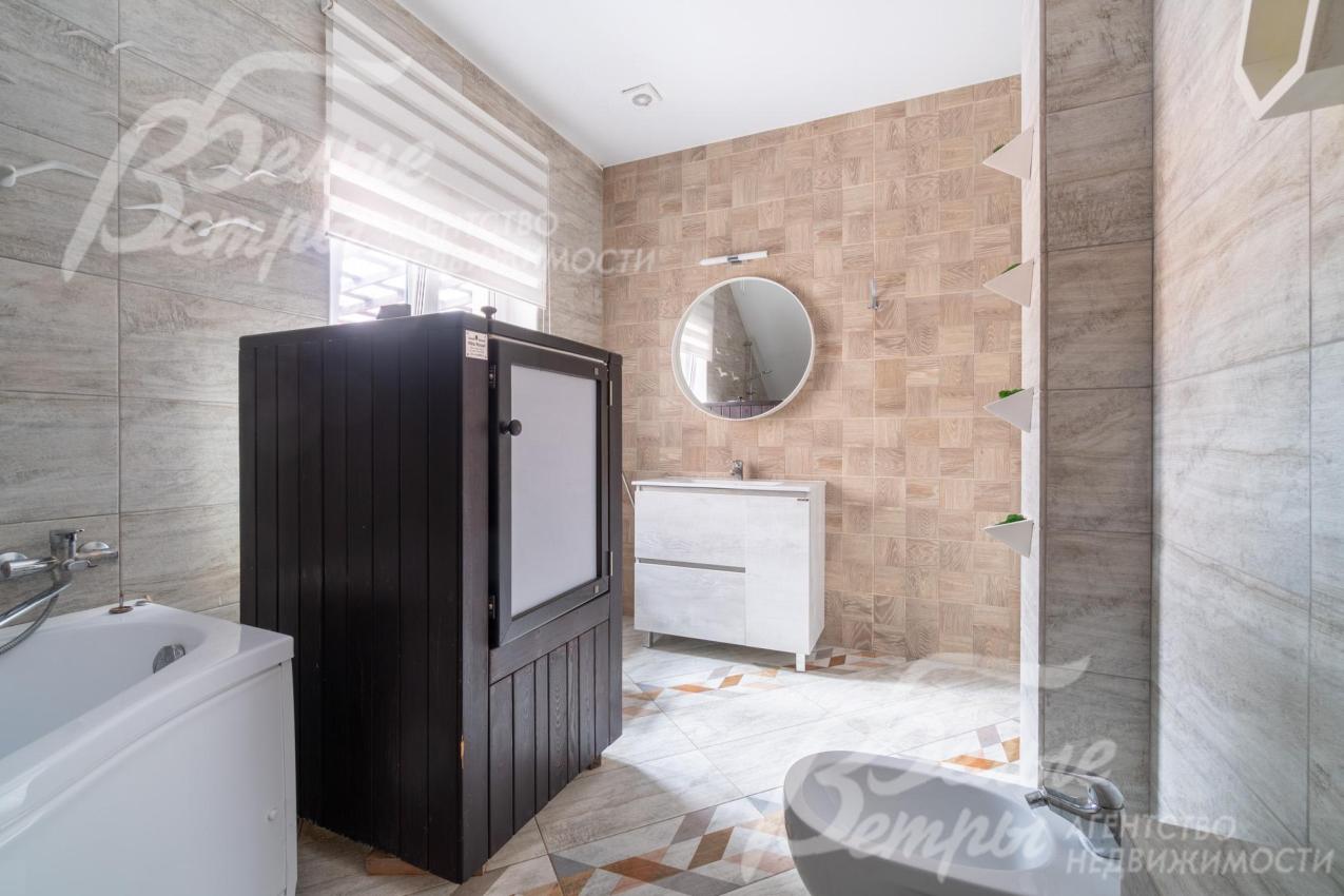 Санузел оформлен плиткой в светлых тонах, в нём есть окно и ванна