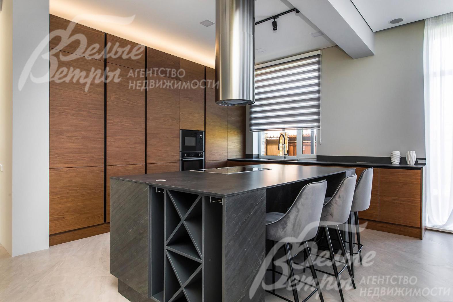 Кухонный гарнитур из шпона ореха, остров облицован шпоном из натурального камня, столешница – Compact HPL FunderMax (Австрия), встроенная техника Neff (Германия)