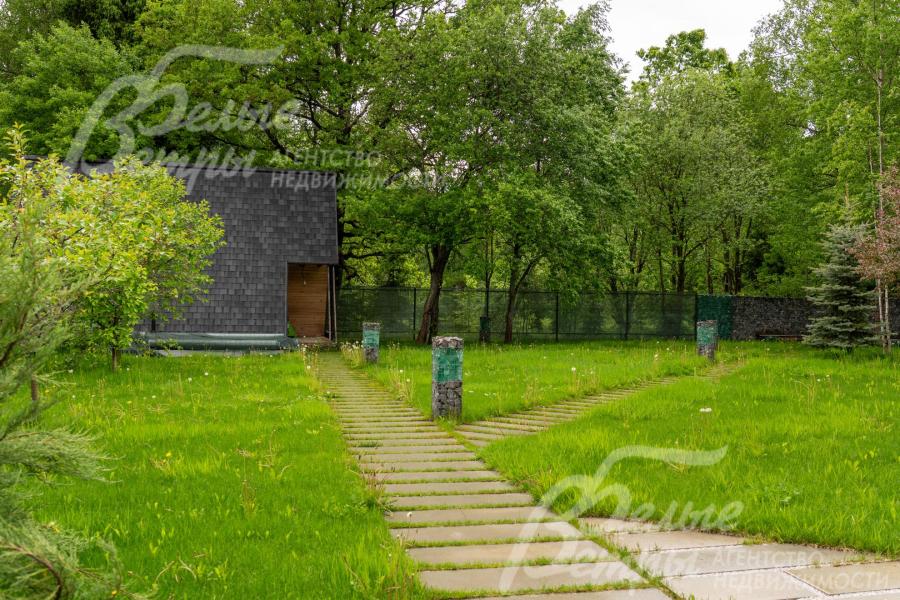Прозрачные секции ограждения не нарушают визуальную целостность ландшафтного дизайна. На участке есть калитка в лес