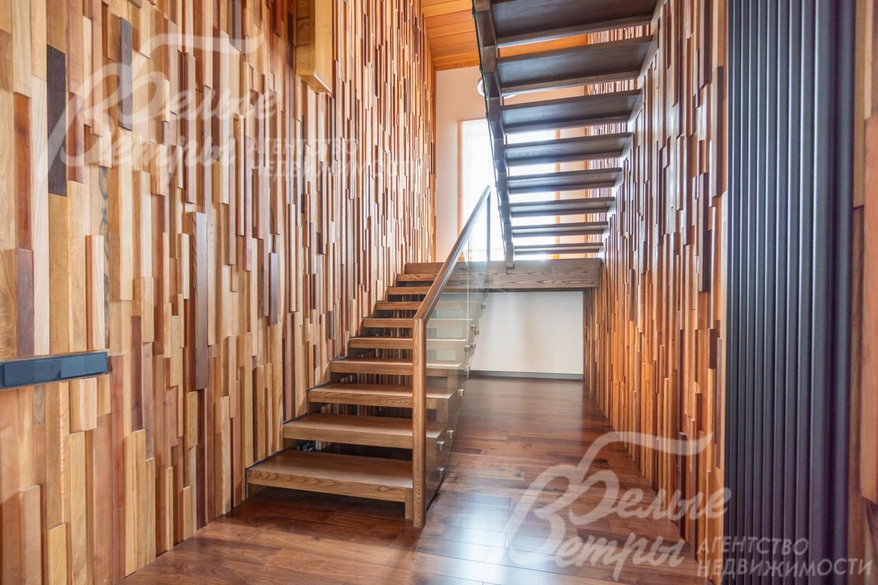 На второй этаж ведет лестница из массива дуба со стеклянным ограждением
