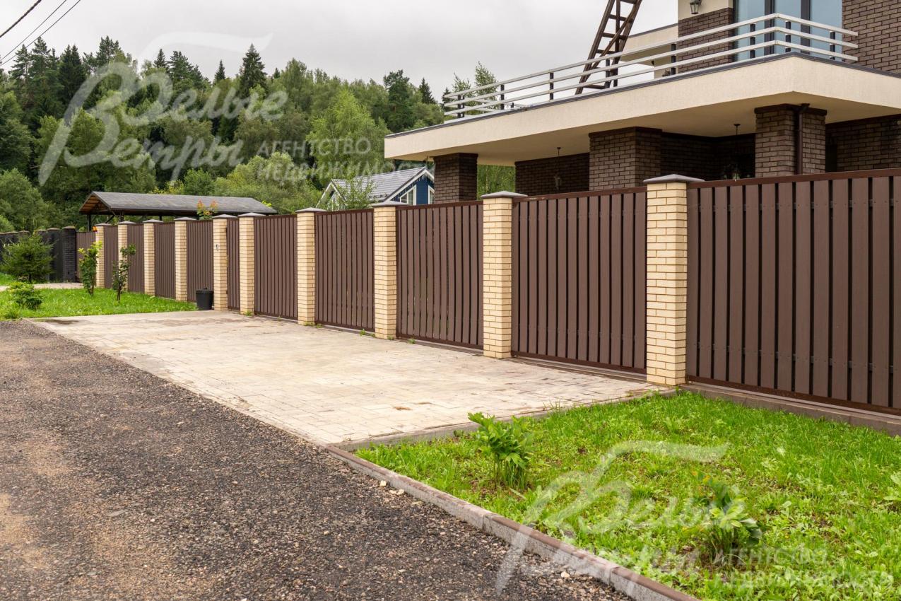 Участок огорожен забором на кирпичных столбах высотой 2 м 