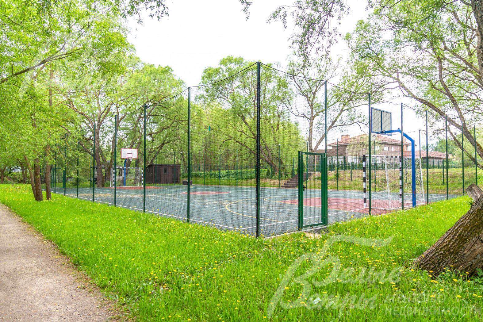 Огороженная спортивная площадка с твёрдым покрытием в поселке