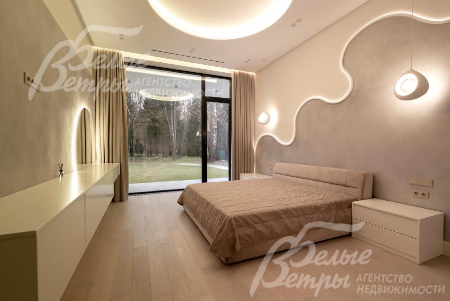 Мастер-спальня укомплектована мебелью, с большим панорамным окном с выходом на террасу