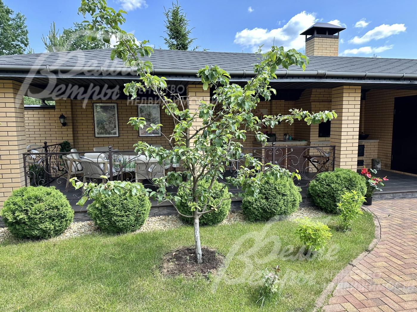 Кирпичные столбы соединяют кованные черные перила в винтажном стиле.