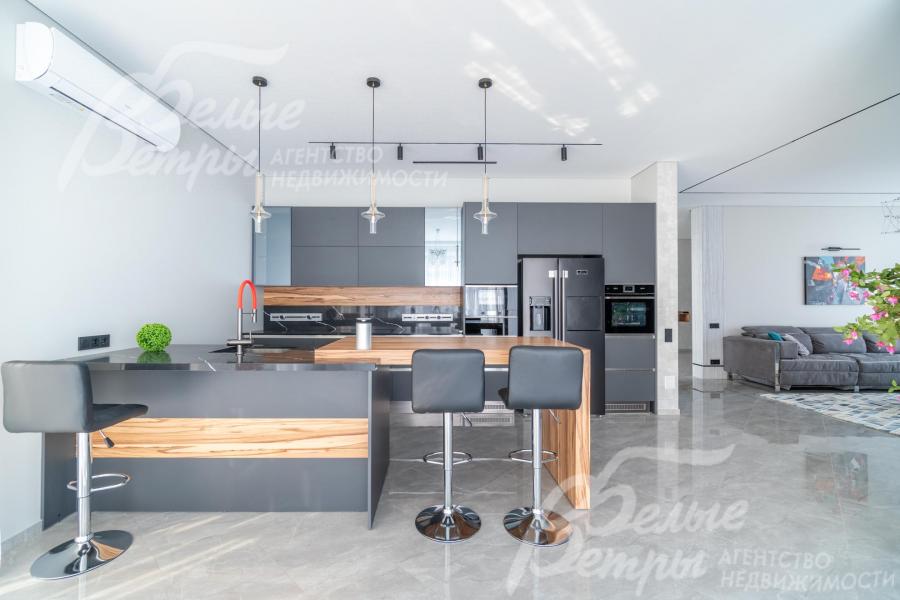 Кухня меблирована: установлен стильный мебельный гарнитур со встроенной техникой