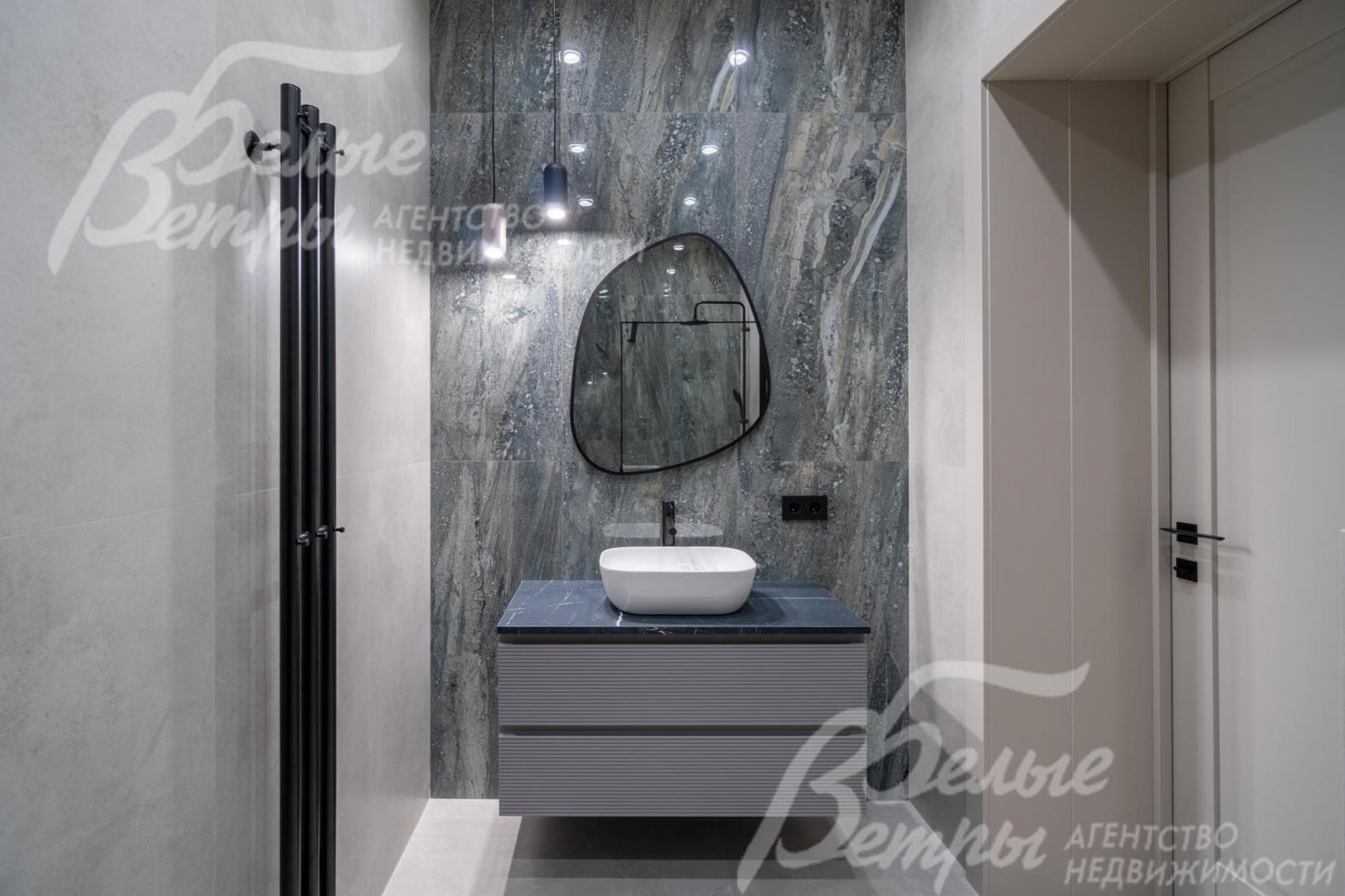 Санузел отделан двухцветной плиткой под мрамор