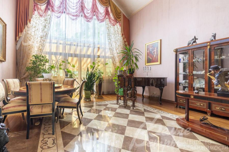 В гостиной стоит обеденная группа и рояль