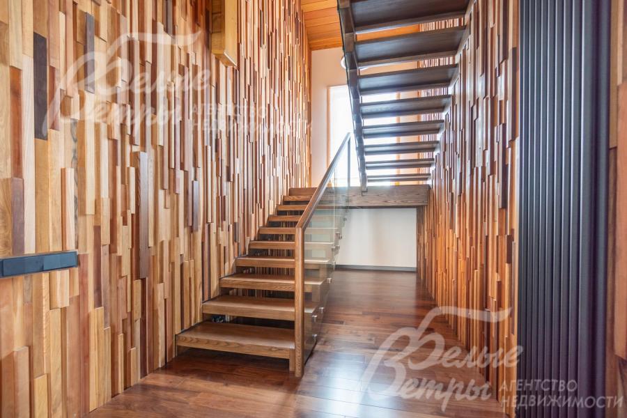 На второй этаж ведет лестница из массива дуба со стеклянным ограждением