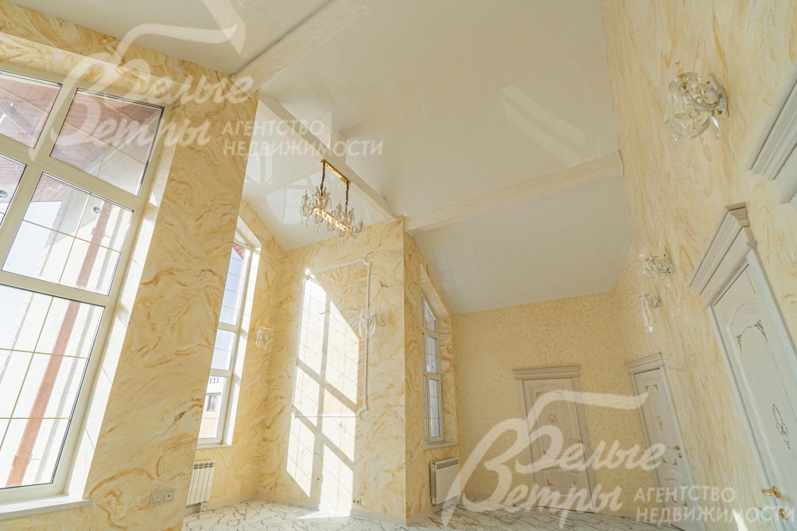 Холл 2-го этажа с панорамными окнами и высоким потолком.