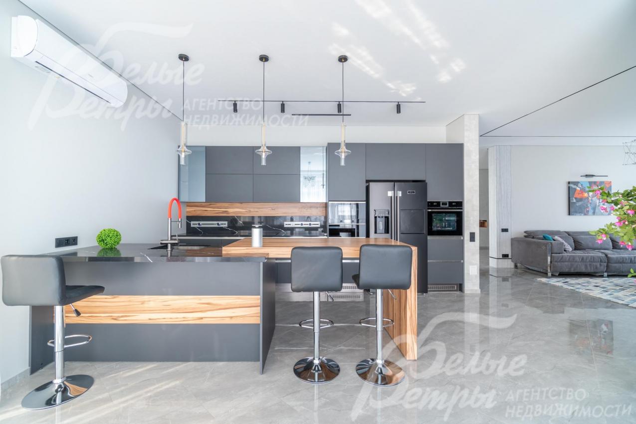 Кухня меблирована: установлен стильный мебельный гарнитур со встроенной техникой