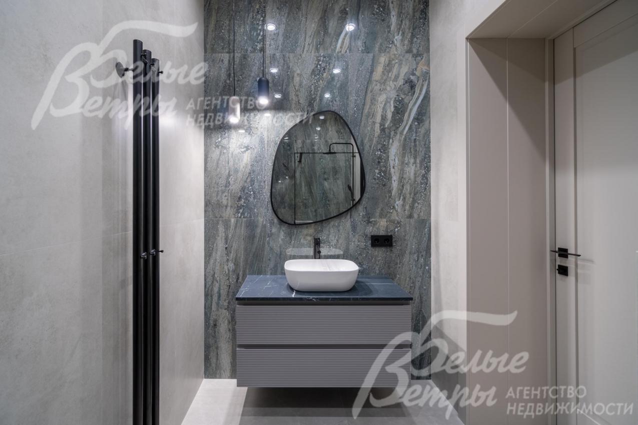 Санузел отделан двухцветной плиткой под мрамор