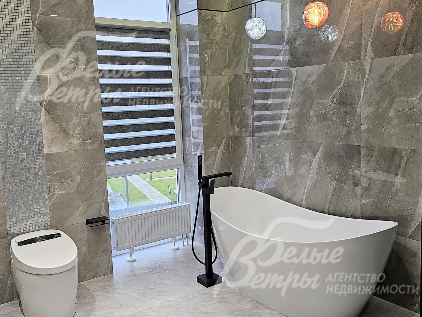 В санузле при мастер-спальне - ванна из литьевого мрамора возле окна