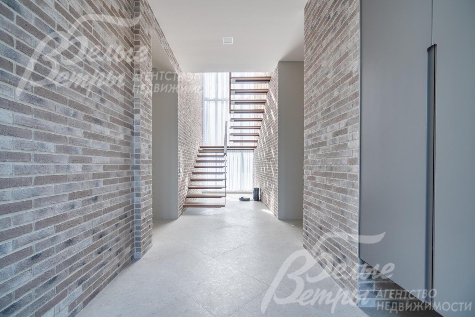 Холл дома: стены отделаны декоративной плиткой «под фасадный кирпич», они органично продолжают внешнюю отделку дома