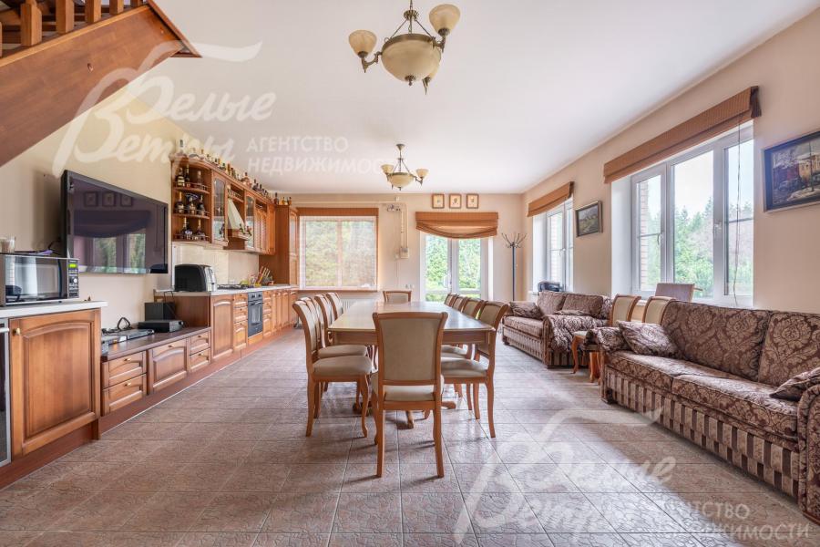 На первом этаже гостевого дома - большая кухня с гарнитуром и обеденной группой
